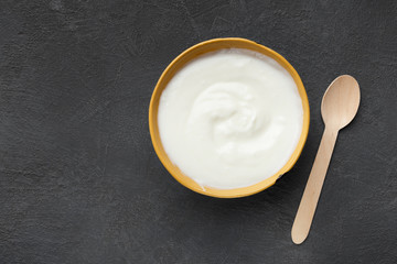 Fototapeta na wymiar Bowl of sour cream on grey background