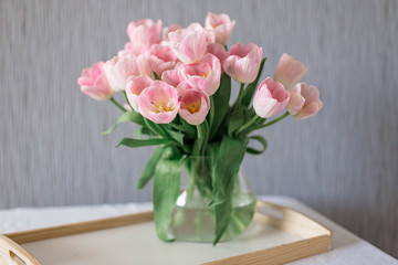 A bouquet of spring beautiful flowers in a glass vase. Fresh Pink tulips on white background.