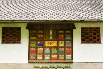 Colorful hand painted apiary beehive covers decorating the side of a building with stone roof at Dornk farm Mlino village Bled Slovenia