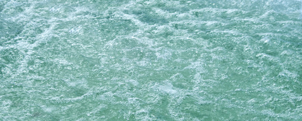 Surface of azure water with bubbles and turbulence