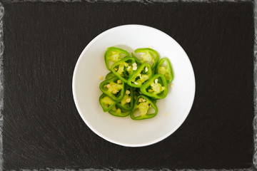 medium hot serenade chillies chopped green on a black background slate