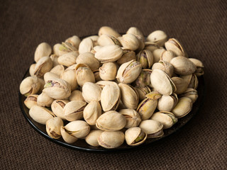 pistachio nuts in bowl on wooden background