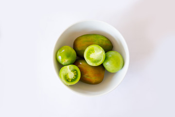 Exotic tomatoes rosa green tomatoes some cut or whole white background with bowl