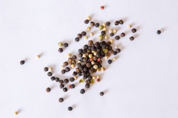 rainbow whole peppercorns red pink green black white on a white background