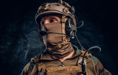 Close-up portrait. Private security service contractor in camouflage helmet with walkie-talkie....