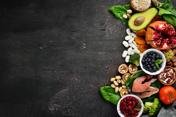 Foto op Plexiglas Gezonde voeding: Vis, bosbessen, noten, granaatappel, avocado& 39 s, tomaten, spinazie, vlas. Concept van dieetvoeding. Bovenaanzicht. © Yaruniv-Studio
