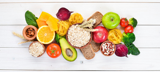 Healthy food containing carbohydrates: bread, pasta, avocados, flour, pumpkin, broccoli, beans,...
