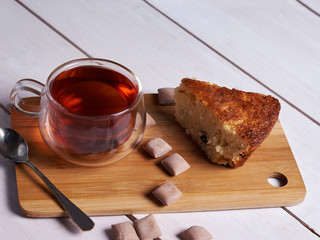 Cake, tea and sweets on a wooden desk.