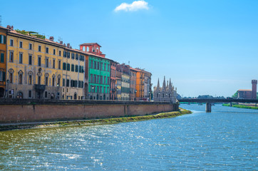 Row of old colorful buildings houses on embankment promenade of Arno river, Chiesa di Santa Maria della Spina church, Ponte Solferino bridge in historical centre of Pisa town, Tuscany, Italy