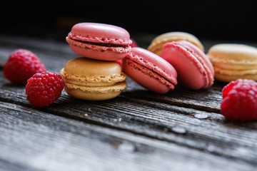 Close-up photo. Colorful French macarons with raspberries on a table