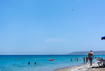 beach, Aegean sea, people on the beach, people swimming in the sea, plane in the Sky, Rhodes coast