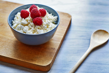 Diet, healthy breakfast. Cottage cheese with fresh raspberries in a bowl