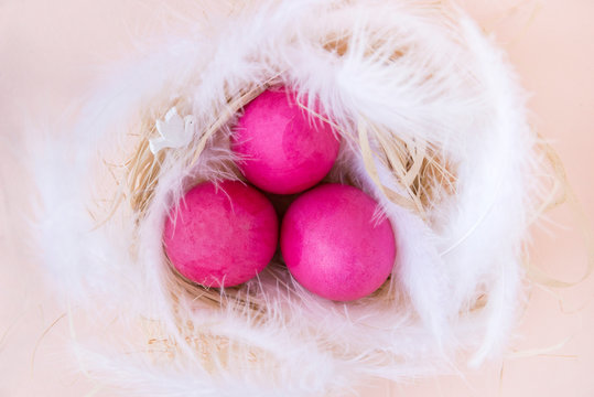 3 pink eggs in the nest with white feathers, dove, Easter - Powered by Adobe