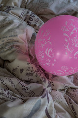 Pink balloon on a ruffled bed - party time concept image with copy space