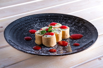 Pancakes stuffed with curd and kiwi decorated with strawberry jam