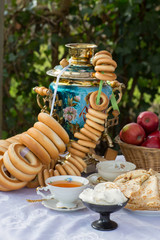 Shrovetide, pancake week.Russian style.Celebration.Tea party at the samovar with bagels, pancakes, jam in the yard.