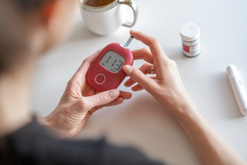 Woman sick on diabetes, is checking her glucose level.