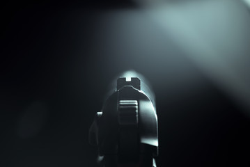 Firearm pistol. Point of view. Low key light.