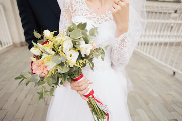 White wedding bouquet in the hands of the bride