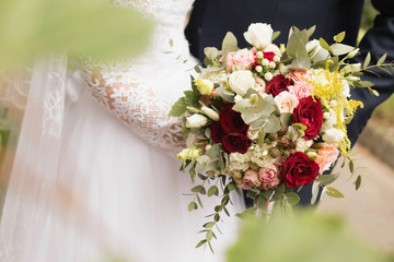 White wedding bouquet in the hands of the bride