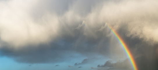 Nuvens com arco íris na hora dourada