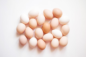 Brown and white eggs on a white surface, the top view