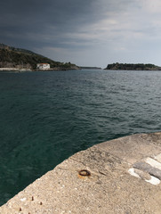 Port curved platform with under dramatic cloudy sky in Mani Greece.