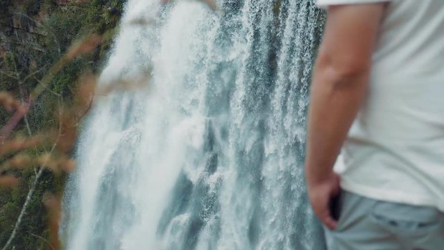 A breathtaking slow motion shot of a man looking at Lisbon Waterfall.