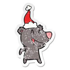 laughing bear distressed sticker cartoon of a wearing santa hat