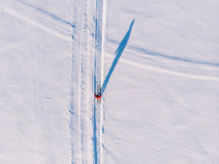 Woman on cross-country skiing rides on snowy track. Leisure concept. Aerial top view