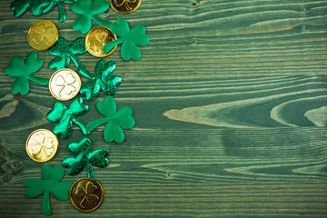 St Patricks Day corner border of shamrocks and gold coins on green wood background