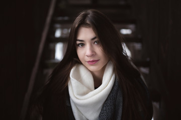 Portrait of pretty girl with beautiful look into camera and delicate skin and long dark hair. Cold...