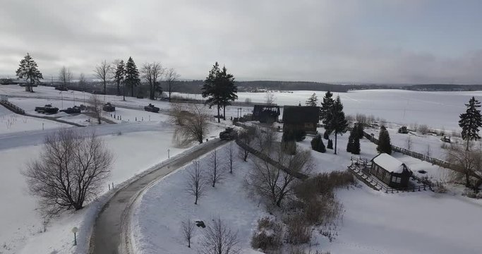 A tank and an armoured vehicle drive across a snow-covered village near Minsk, Belarus