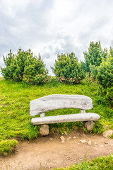 Alpe di Siusi, Seiser Alm with Sassolungo Langkofel Dolomite, a stone bench sitting in the middle of a field