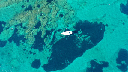 Aerial birds eye view from drone of sail boat in turquoise water, island of Mykonos, Cyclades, Greece