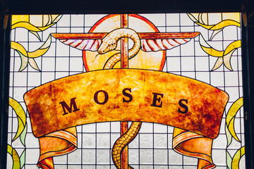 Moses painting on stained glass window. Brazen serpent on stick.