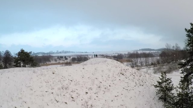 Girls trying yoga on snowy hill. Aerial shot on snowy hill.
