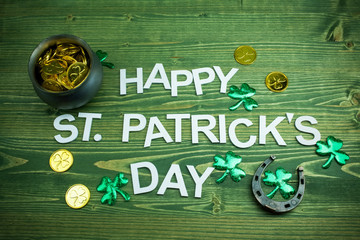 Happy St Patricks Day letters on green wooden background