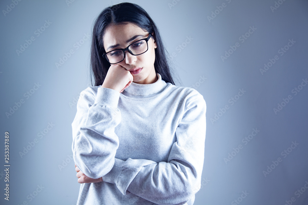 Wall mural sad young woman in gray background