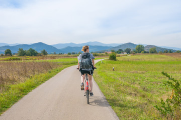 Fototapeta na wymiar woman biking through the fields in central croatia