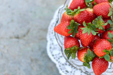 plate of strawberries on light background.