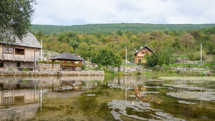 old wooden mill and bridge at gacka river spring in central croatia © Janine