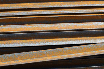 Rusty metal L-bar angle at the warehouse of metal products piled in the open air