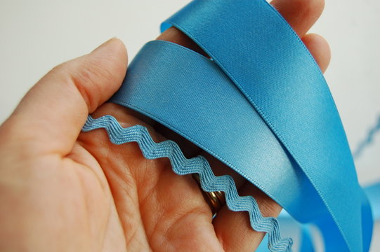 hand with blue ribbons and ric rac