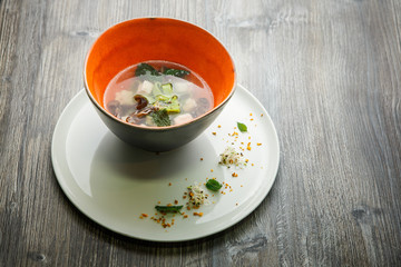 traditional noodle soup with mushrooms, meat, and nettle leaves