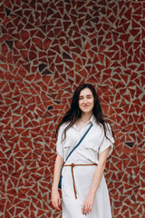 Beautiful attractive smiling woman staying on orange wall background