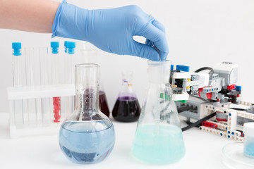 Science school, Medicine. A teenager boy conduct chemical experiments with tubes. On the table is a robot. STEM and STEAM education. Science and technology. Chemistry lab.