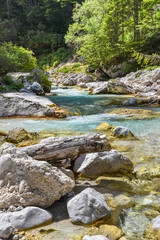 Naklejka na ściany i meble Beautiful blue colored stream in Triglav National Park in Slovenia, central Europe.
