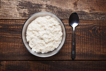 oatmeal with spoon on brown wooden background