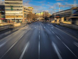Fototapeta na wymiar Motion Blur POV Shot of an Empty City Street in Europe - with Buildings and a Bridge in the Background